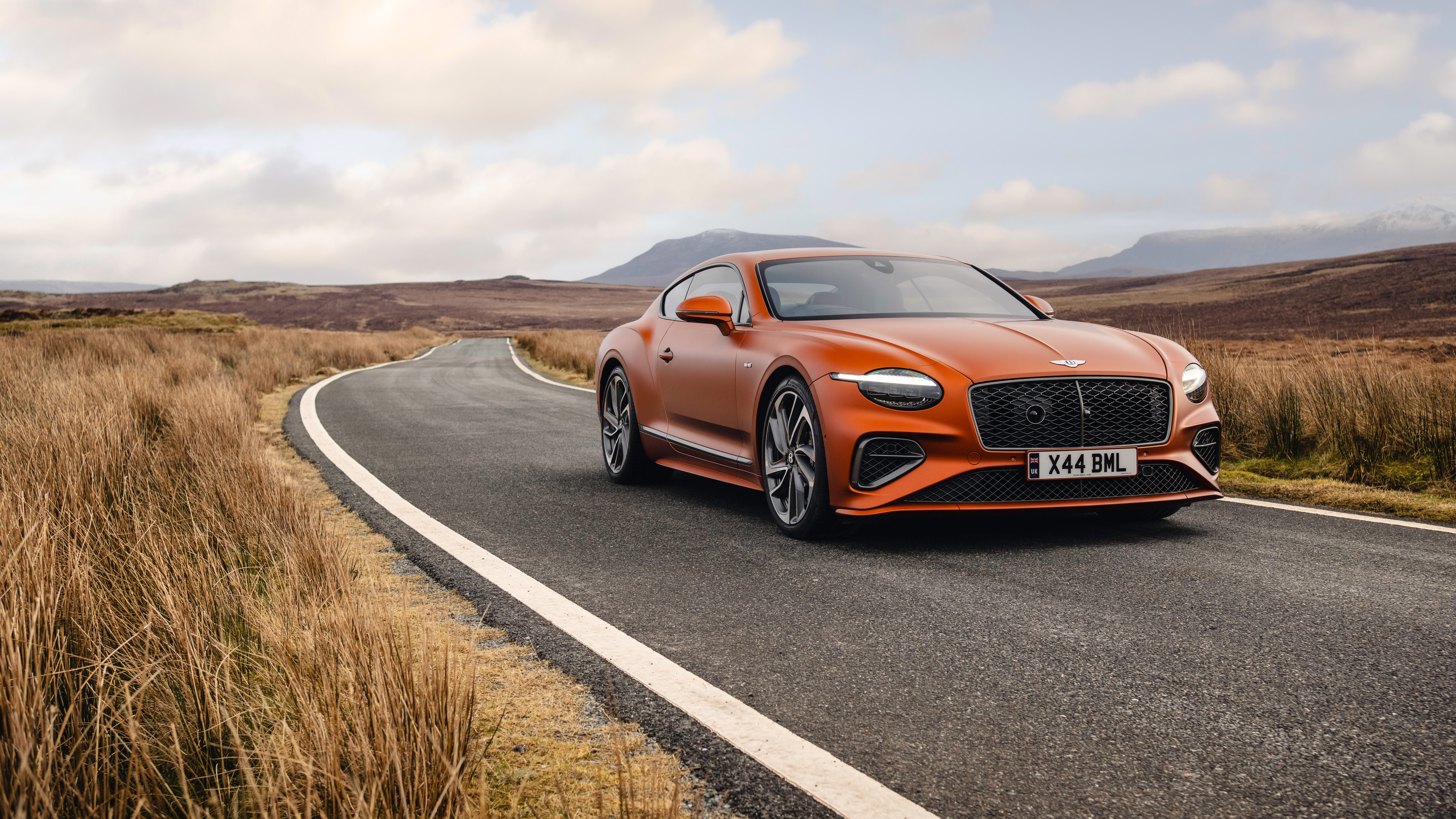 Яскравий помаранчевий Bentley Continental GT Speed, що демонструє свій розкішний дизайн і потужний вигляд.