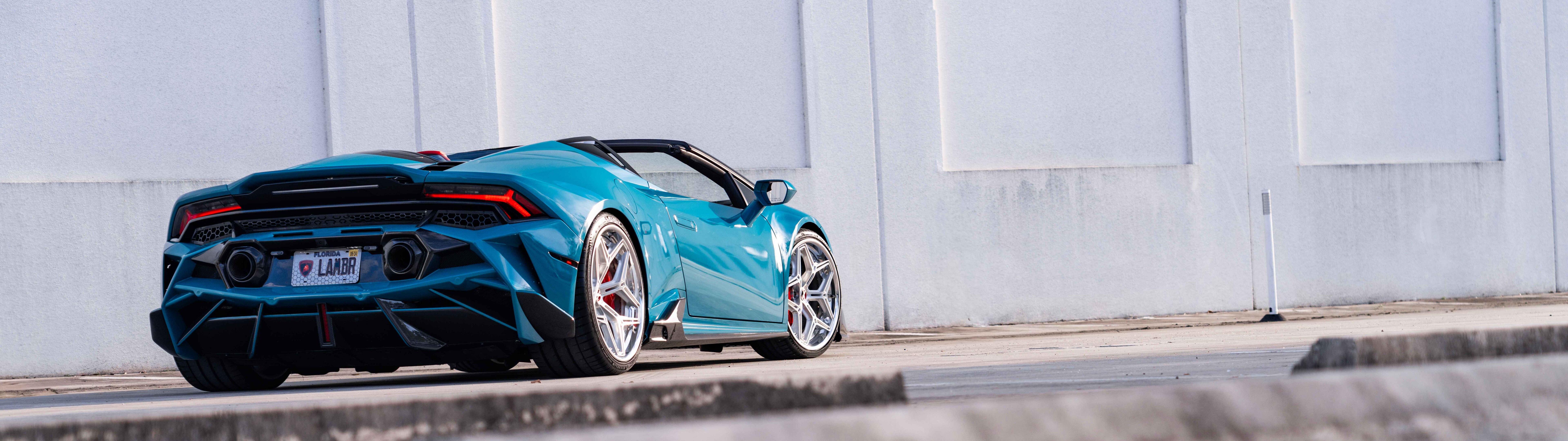 Детальний вигляд автомобіля Lamborghini Huracan Evo, на якому можна розгледіти його фірмовий аеродинамічний кузов і витончений силует суперкара.