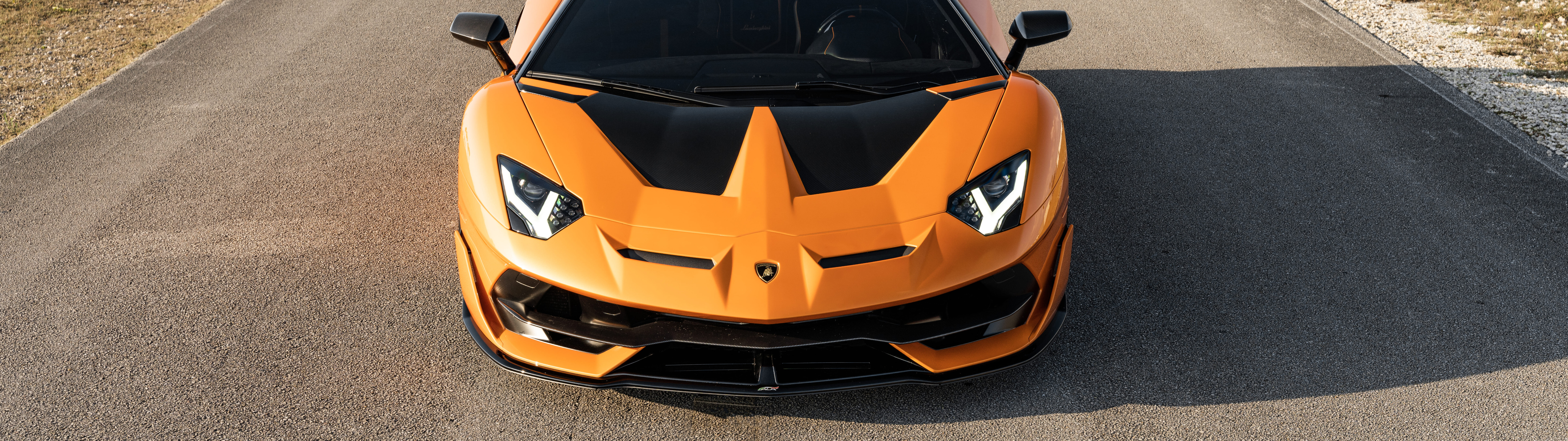 Зображення Lamborghini Aventador SVJ крупним планом, на якому можна розгледіти її обтічний аеродинамічний кузов і виразний силует потужного суперкара.